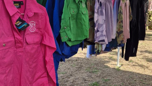 Fugu's Dundee Downs NT work shirts in pink, blue, green and camo on a rack at the Dundee Beach Markets