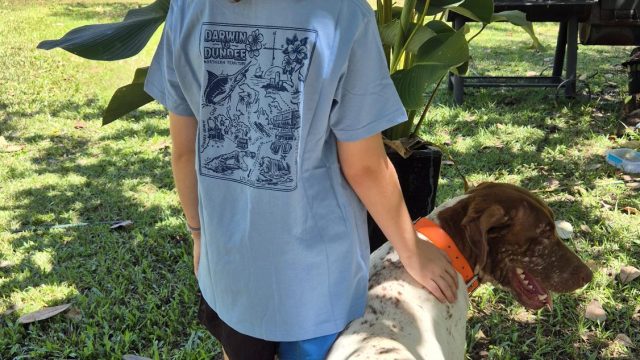 Girl wearing a Fugu's Darwin to Dundee printed t-shirt with her dog at Dundee Beach