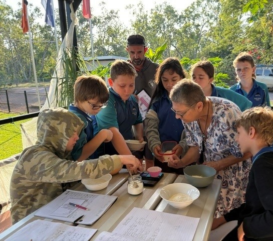 Dundee Beach School students making bread outdoors with a local