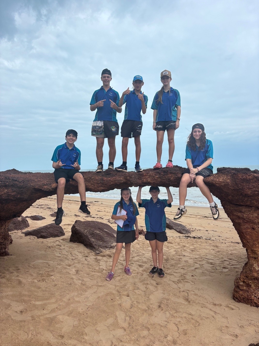Years 7 to 9 students from Dundee Beach School on a rocky headland by the beach