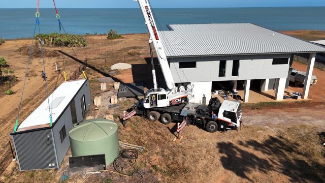 Xtreme Crane Hire crane placing a site shed at a beachfront house build in the NT