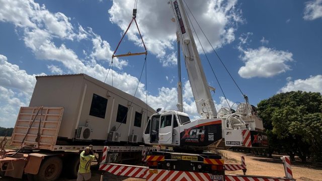 Xtreme Crane Hire crane unloading a transportable building from a truck
