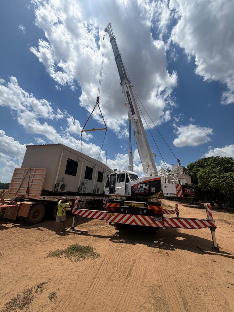 Xtreme Crane Hire crane unloading a transportable building from a truck